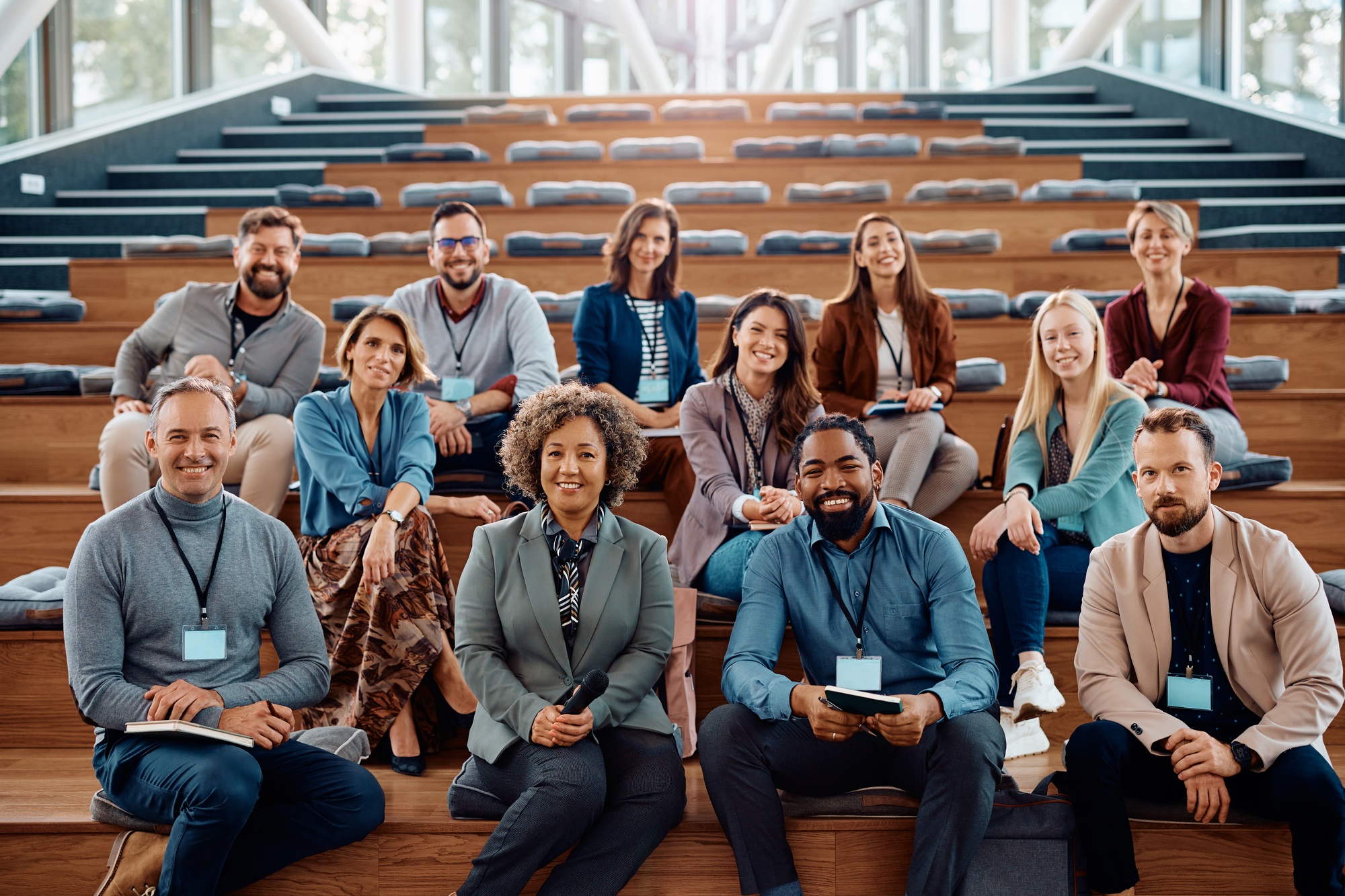 Multiracial group of happy business seminar attendees at convention center looking at camera.